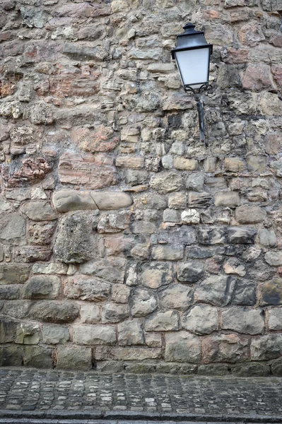 Antiguo muro de piedra con linterna — Foto de Stock