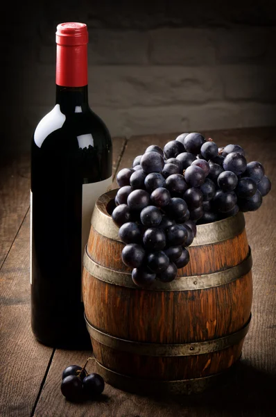Butelka czerwonego wina, beczki i winogron — Zdjęcie stockowe