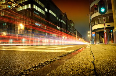 Urban city road with car light trails at night clipart