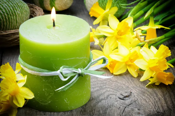 Spring setting with yellow narcissus and candle — Stock Photo, Image