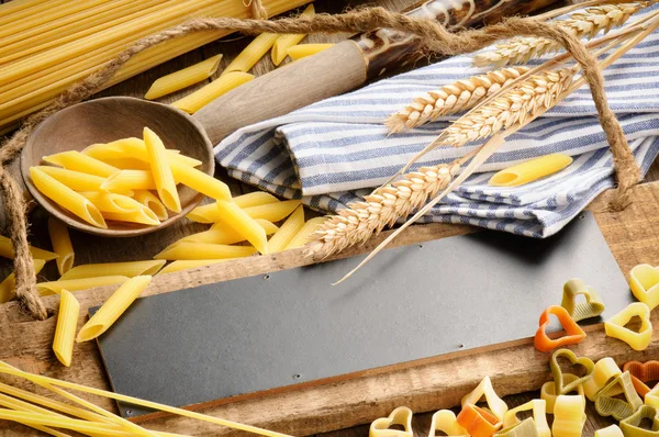 Tablero rústico de madera con surtido de pasta — Foto de Stock