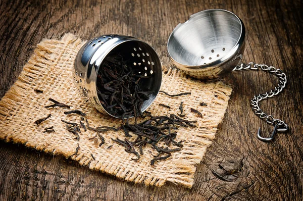 A fából készült asztal fém tea infuser — Stock Fotó