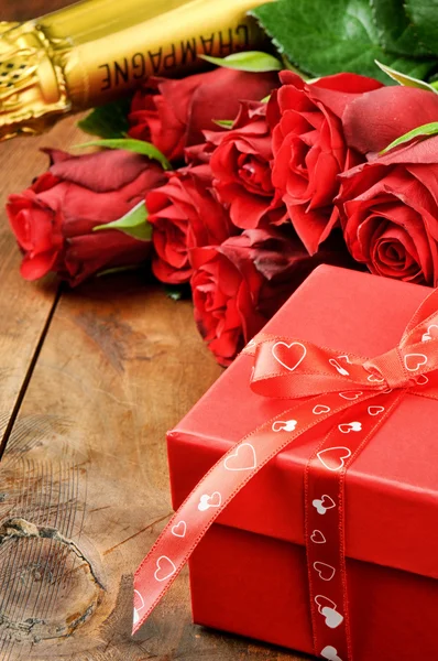 Ajuste de San Valentín con rosas rojas, champán y caja de regalo — Foto de Stock