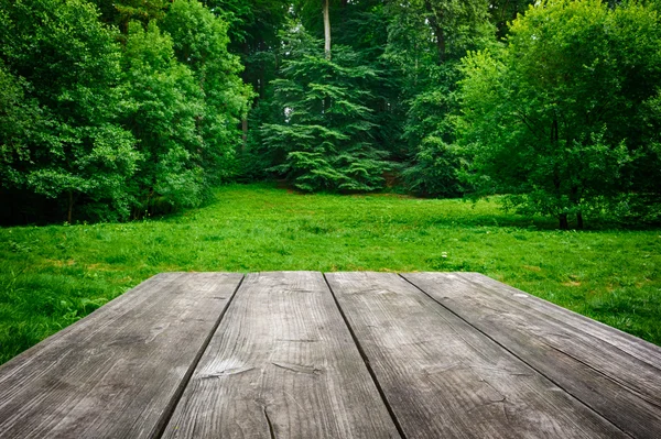 Mesa de madeira com fundo de natureza verde — Fotografia de Stock