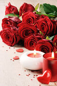 Rote Rosen und Kerzen vor dem Hintergrund des Valentinstages