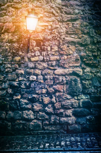 Antiguo muro de piedra con linterna — Foto de Stock