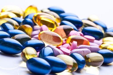 Colorful vitamin gel capsules isolated on whiteback ground clipart