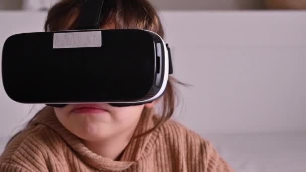 Niña inteligente que usa auriculares de realidad aumentada, con gestos que manipula el proceso. Gafas 3D, el concepto de juegos modernos para niños y adultos. — Vídeo de stock