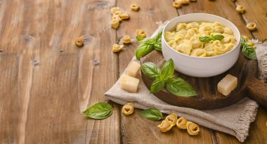 Tortellini çorbası, ahşap bir tahtada parmesanlı brodo. Bologna ve Emilia Romagna mutfağının spesiyaliteleri: Cappelletti, et ve sebzeli taze yumurtalı makarna.