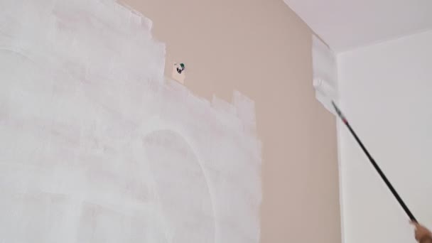 Painter paints the wall. close-up of paint roller — Stock Video