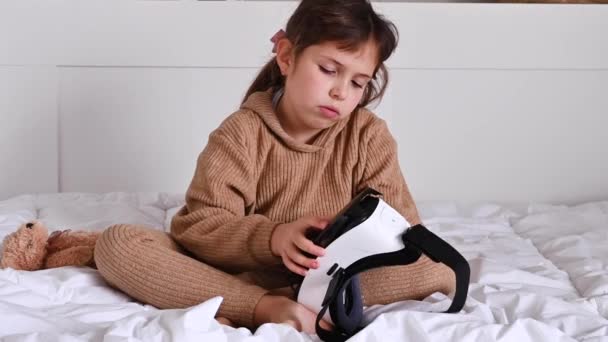Smart Little girl Wearing Augmented Reality Headset Plays .she instala el juego, gafas 3D, el concepto de juegos modernos para niños y adultos — Vídeo de stock