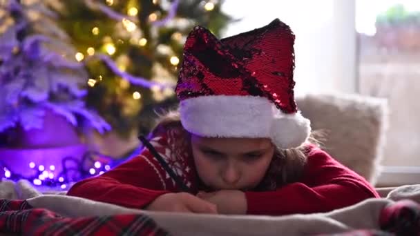 Sladké dítě je psaní dopisu Santa Claus v místnosti, zdobené na Vánoce, příprava na dovolenou - vánoční duch, svátky a oslavy koncept — Stock video