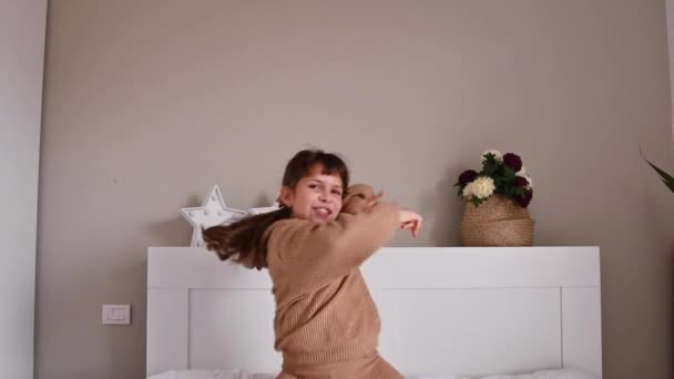 Menina dançando e se divertindo no quarto na cama — Vídeo de Stock