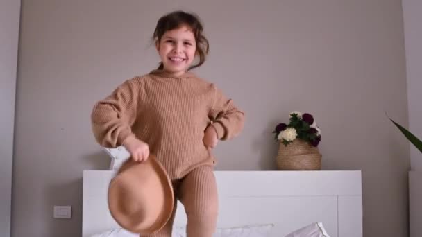 Μικρό κορίτσι χορεύει και διασκεδάζει στο δωμάτιο στο κρεβάτι — Αρχείο Βίντεο