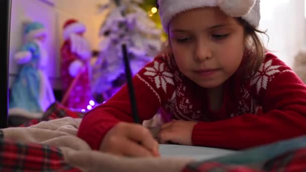 Süße Kind schreibt einen Brief an Weihnachtsmann im Zimmer, dekoriert für Weihnachten, Vorbereitung für die Feiertage - Weihnachtsstimmung, Feiertage und Feiern Konzept — Stockvideo