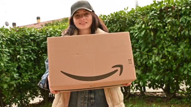 Амазонський кур'єр з великою коробкою в руках біля входу в будинок. Посміхнися з дивним магазином. Інтернет-магазин і концепція доставки — стокове відео