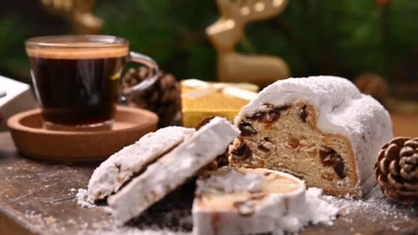 Столлен. Традиционный немецкий сладкий хлеб с сухофруктами и марципаном на Рождество. Ароматический кофе эспрессо возле елки и сладостей — стоковое видео