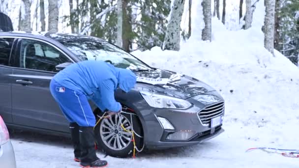 February 15, 2021. Italy city of Cestola. winter chains on wheels. Man puts on protective chains on the car in the winter forest in the mountains — Video Stock