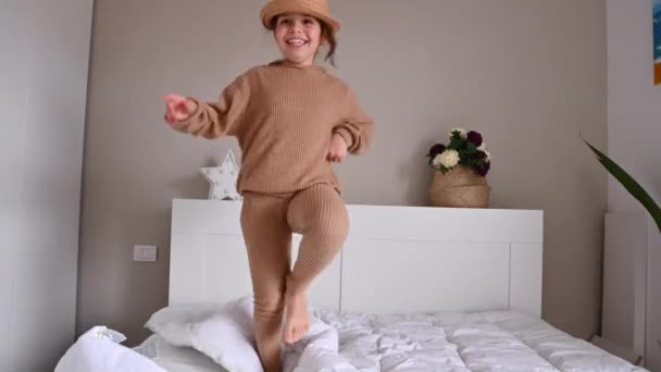 Niña bailando y divirtiéndose en la habitación en la cama — Vídeo de stock