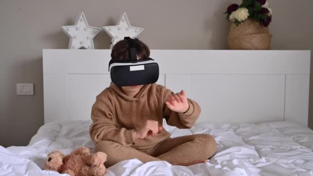 Smart Little girl Wearing Augmented Reality Headset Plays .she instala el juego, gafas 3D, el concepto de juegos modernos para niños y adultos — Vídeo de stock