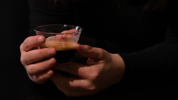 Een kop espresso in de handen van een vrouw. close-up. Donkere foto. — Stockvideo