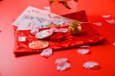 Çin Yeni Yıl Festivali dekorasyonu ya da kırmızı paket, turuncu ve altın külçeler ya da kırmızı arka planda altın tomar.