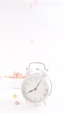 Çalar saat çalar ve çocukların kahvaltı gevrekleri bir kaseye dökülür ve bir bardak portakal suyu dökülür.. 