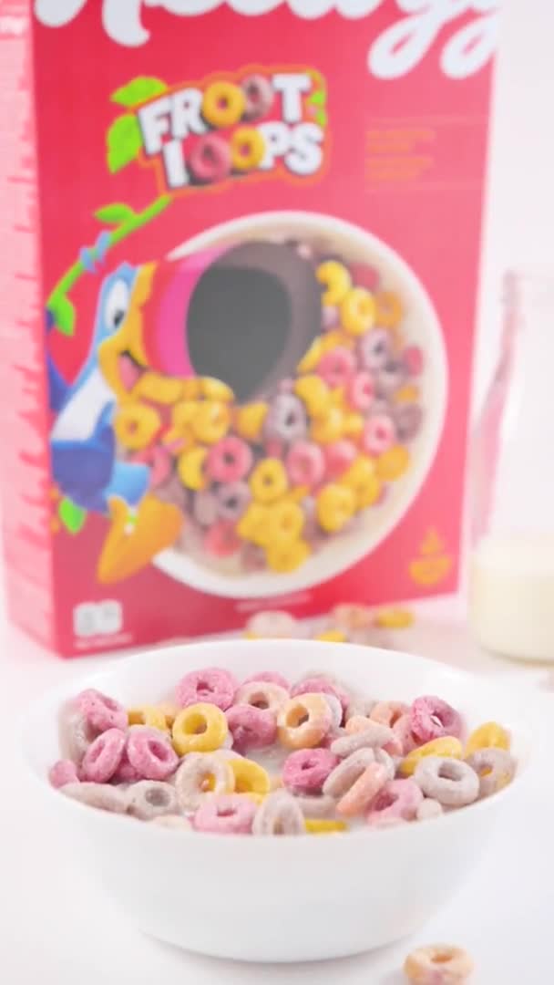 干早餐凯洛格斯在一个装有牛奶的碗里生根.孩子们早餐用的五颜六色的戒指。用于智能手机和社交网络的垂直格式。勺子里的食物特写. — 图库视频影像