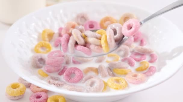Droog ontbijt in een kom met melk. Multi-gekleurde ringen voor kinderen ontbijt — Stockvideo