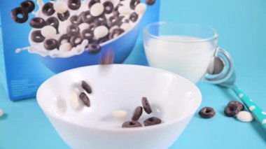 Kahvaltıyı sütlü bir kasede kurut. Çocukların kahvaltısı için siyah-beyaz kremalı çikolata halkaları.