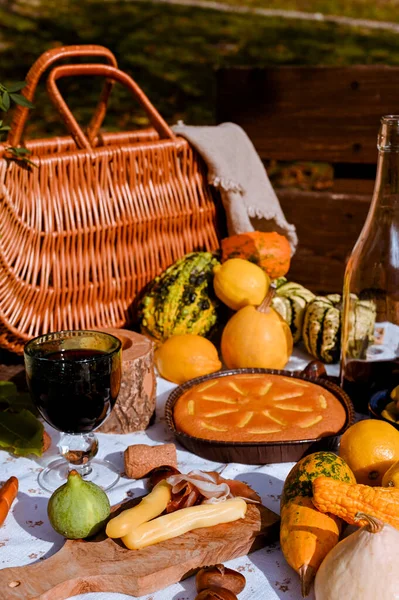 Осінній пікнік. Стіл готовий до обіду восени, пікнік. Жниво, осінній обід, вино і окуляри. Зібрання на вулиці. — стокове фото