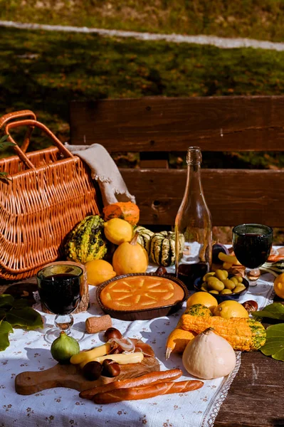 Un picnic d'autunno. Tavolo preparato per il pranzo nella natura autunnale, picnic. Vendemmia, pranzo autunnale, Vino e bicchieri. Incontro all'aperto. — Foto Stock