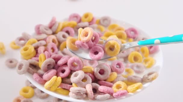 把早餐放在有牛奶的碗里烘干 孩子们早餐用的五颜六色的戒指 一只勺子里的食物的特写 高质量的镜头 — 图库视频影像