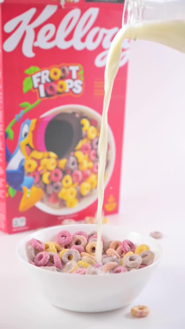 干早餐凯洛格斯在一个装有牛奶的碗里生根 孩子们早餐用的五颜六色的戒指 用于智能手机和社交网络的垂直格式 慢动作 2022年10月5日意大利博洛尼亚 — 图库视频影像