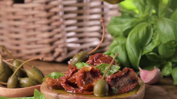 製品の横にあるピマラ バジルのオリーブオイルとケッパーで乾燥トマト 油を漏らしてる 伝統的なイタリア料理とスペイン料理の前菜 高品質4K映像 — ストック動画