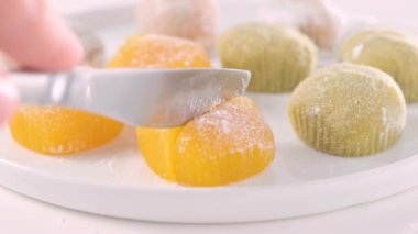 Geleneksel Japon tatlıları. Beyaz bir masanın üzerinde renkli mochi dondurması, böğürtlenli ve meyve dolgulu. Çocuklar için çocuklar günü tatili tatlısı. Yüksek kalite 4k görüntü