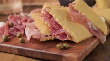 Hilal çiçeği. Emilia Romagna bölgesinin yiyeceği, kızarmış ekmek gnocco fritto ya da Crescentina. İtalya 'da aperatif veya aperatif. Prosciutto crudo, mortadella, Milano salamı, kapari, peynir ile Creshantina 