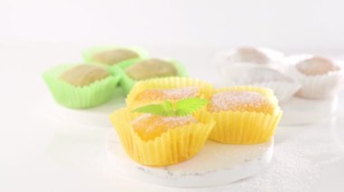 Geleneksel Japon tatlıları. Beyaz bir masanın üzerinde renkli mochi dondurması, böğürtlenli ve meyve dolgulu. Çocuklar için çocuklar günü tatili tatlısı. Yüksek kalite 4k görüntü
