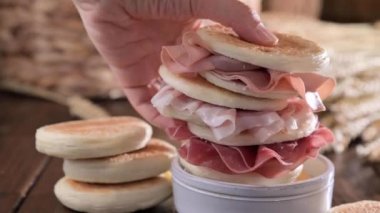 Tigelle veya crescentine ev yapımı, Moden bölgesinin tipik İtalyan yemeği. Prosciutto ile doldurulmuş ince yuvarlak ekmekler. Emilia-Romagna. Un, su, tuz ve mayadan yapılmış. Seçici odak 45 'liği