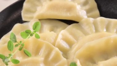 Dim sum. Ev yapımı Çin köfteleri siyah bir tabakta servis edilir. Yemek çubuklarıyla yiyorlar. Doğu mutfağı, geleneksel öğle yemeği için hafif atıştırmalıklar. Yüksek kalite 4k görüntü