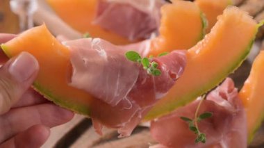 Kavunlu İtalyan jambonu. Kavunlara sarılmış geleneksel jambon dilimleri. Lezzetli aperatif. Yemek arkaplanı. Kapatın. Şarap için aperatif.