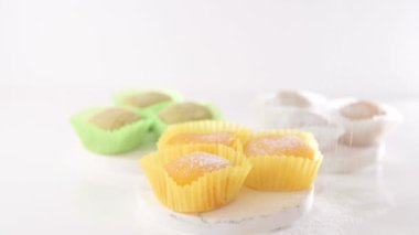 Traditional Japanese dessert mochi. Colorful mochi ice cream on a white table, whole and cut with berry, fruit filling. Sweetness for children on the boys day holiday. 