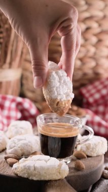 Sicilian Almond Cookies - Almond Pastes. Traditional dessert of the South of Italy and a cup of fragrant espresso on a wooden table. The atmosphere of an Italian village. 4k vertical video