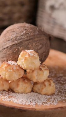 Coconut cookies. Homemade gluten free pastry with coconut. Small round sweets on a wooden table. High quality photo. Coconut shavings and real coconut are pouring