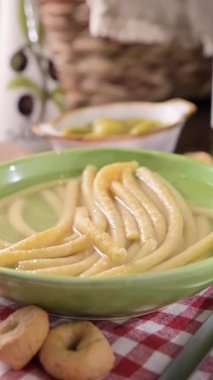 Italian Passatelli. Traditional Italian pasta cooked in broth. View from above. Bologna, Italy. Typical cuisine of Emilia Romagna Italy. High quality 4k footage. Vertical video