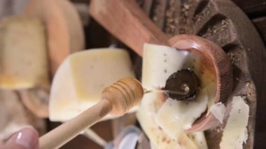 Pecorino cheese with truffle, traditional Italian sheeps milk cheese with truffle. A typical product of the dairy regions of Tuscany and Sardinia. Honey and cheese, Vertical video