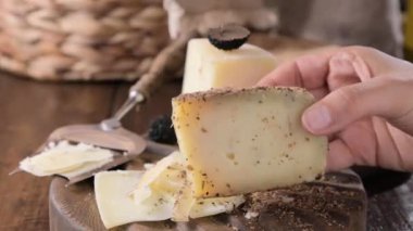 Cheese Piece with beer. The L ottavio is a variety of handmade cheese produced with milk of a Bruna cow and beer. It is covered with barley malt and has a brown color. Italian Cuisine. 