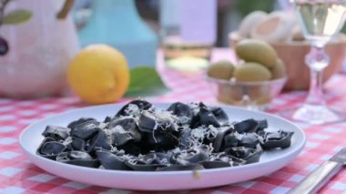 Outdoor lunch. Black tortellini and served table. Italian cuisine for a summer dinner in the garden. High quality FullHD footage