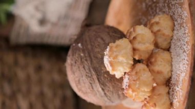 Coconut cookies. Homemade gluten free pastry with coconut. Small round sweets on a wooden table. High quality photo. real coconut are pouring. Vertical video