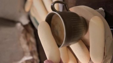 Cup of aromatic black espresso coffee and Cats tongues These are thin and tender cookies made from egg yolks and sugar. Traditional in different regions of Europe in Italy, the Netherlands, vertical
